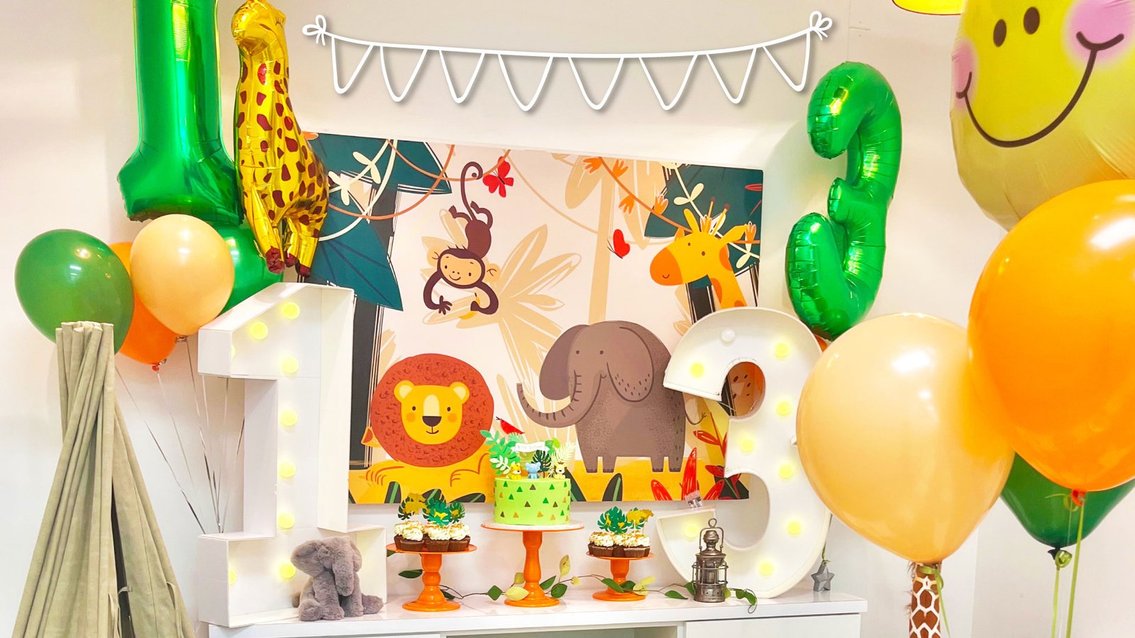 Safari themed birthday party at Kids Hideout with themed decorations, balloons, and cake